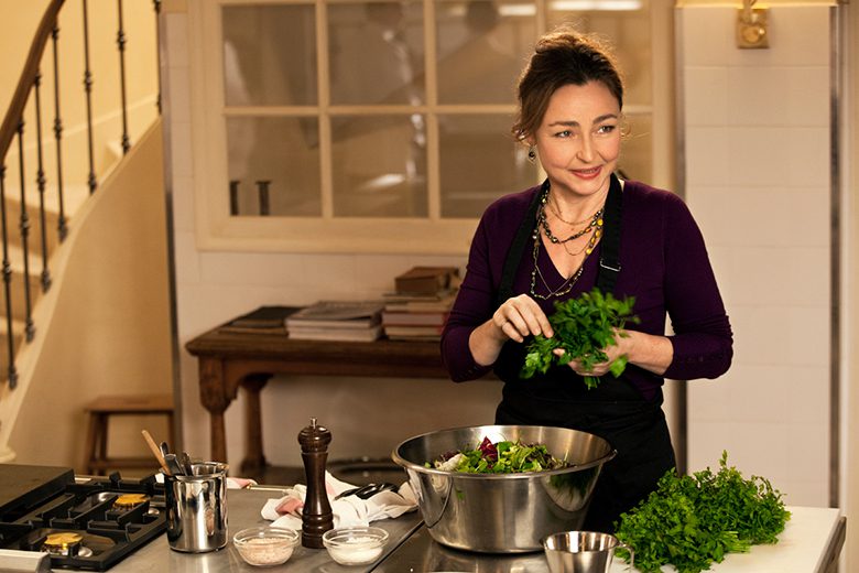 Sabores do Palácio. Descrição da imagem: mulher colocando ervas e temperos em uma tigela de aço inox.