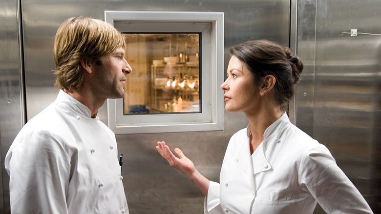 Sem Reservas. Descrição da imagem: homem e mulher vestidos com uniforme de cozinheiro, discutindo.