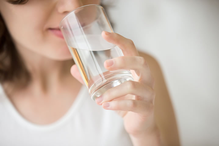 Erros alimentares: Diminuir a ingestão de água. Descrição da imagem: mulher bebendo água.