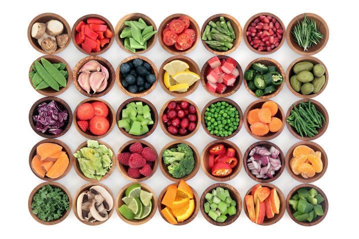 Erros alimentares: Deixar de consumir saladas e frutas. Descrição da imagem: várias tigelas de frutas e legumes vistas de cima.