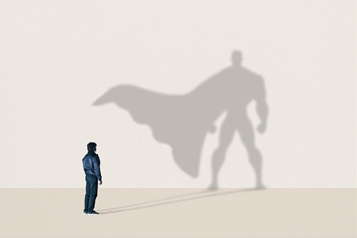 Imagem com homem de frente a uma parede. A projeção da sua sombra mostra um herói com uma capa. Fonte: gettyimages 